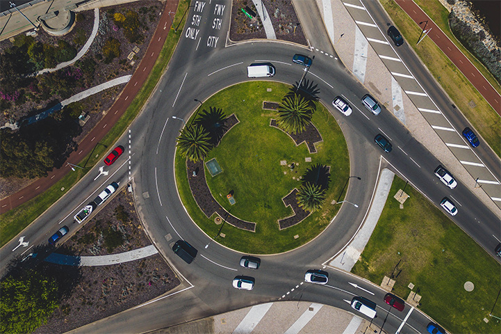 A large sealed roundabout with multiple roads going in and out of it.