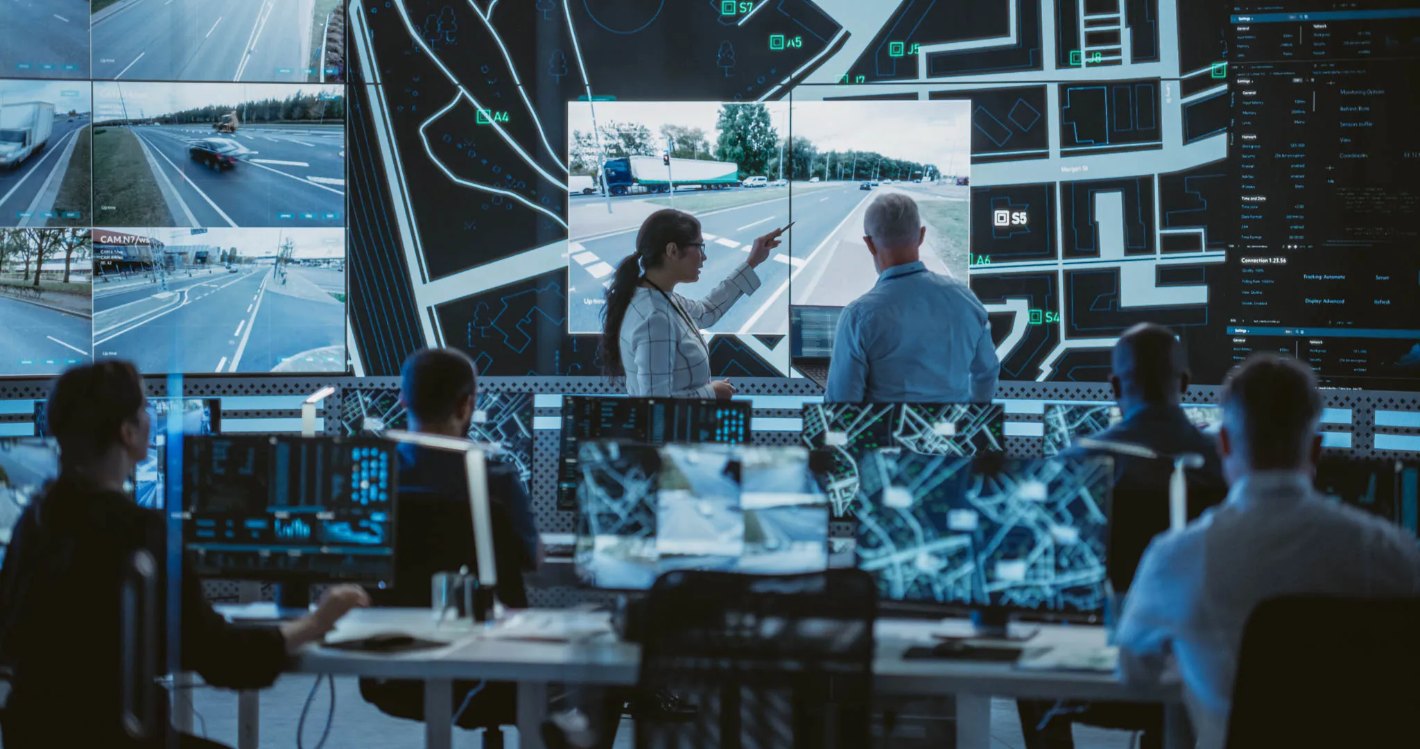 Group of people in a room looking at a computer with roads on it assessing the safety risks.