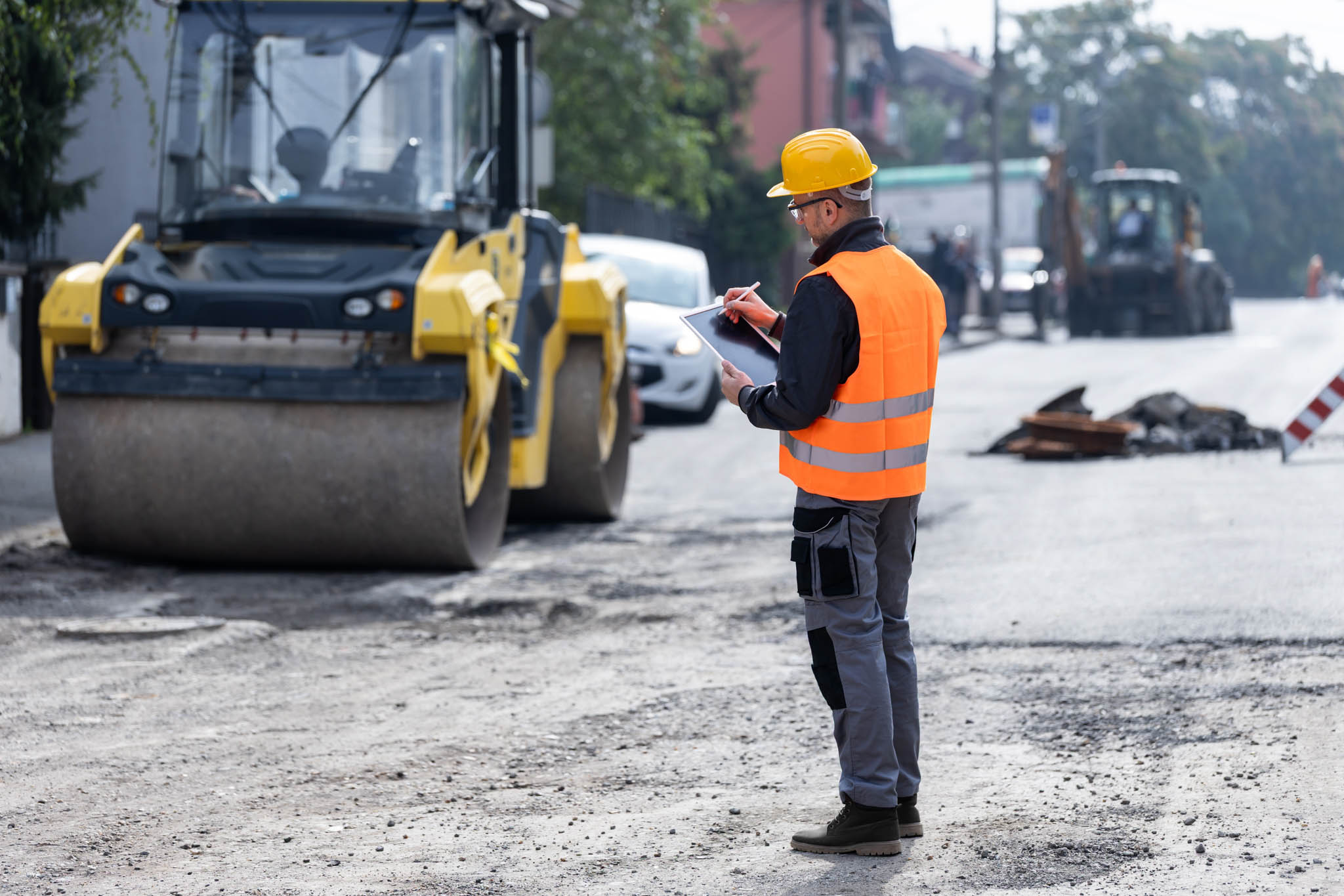 Civil engineer looking at an iPad while on a road work site.