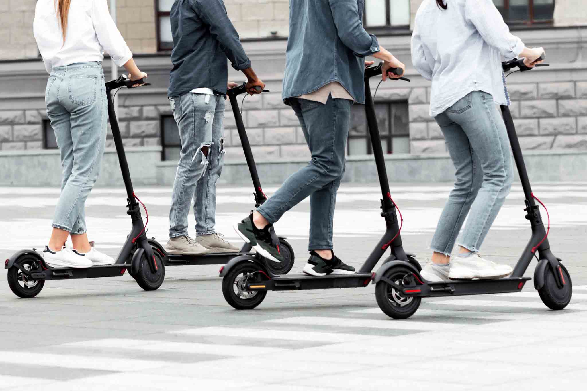 Multiple people riding e-scooters.
