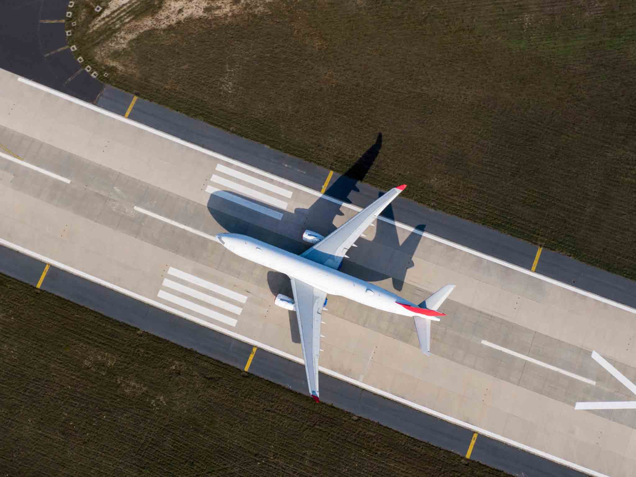 Ariel view of a plane on an airport runway.