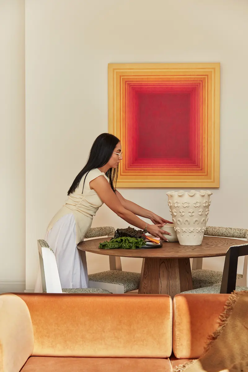 A woman in front of an abstract painting.