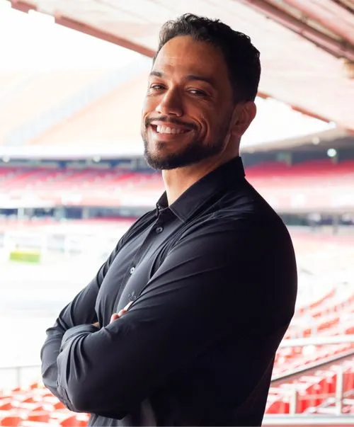 A man wearing a black shirt and smiling.