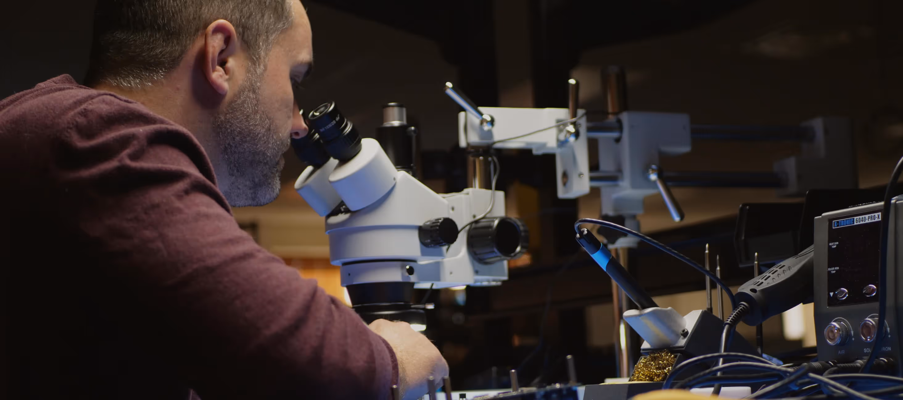 A man checking hardware in a microscope