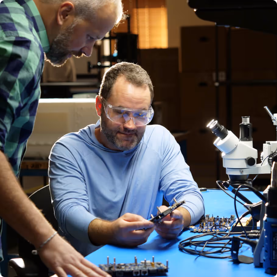 Two people staring at a piece of hardware