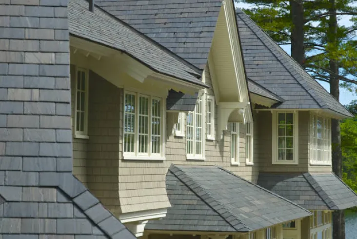 Close-up of a house with slate roofing and multiple windows.