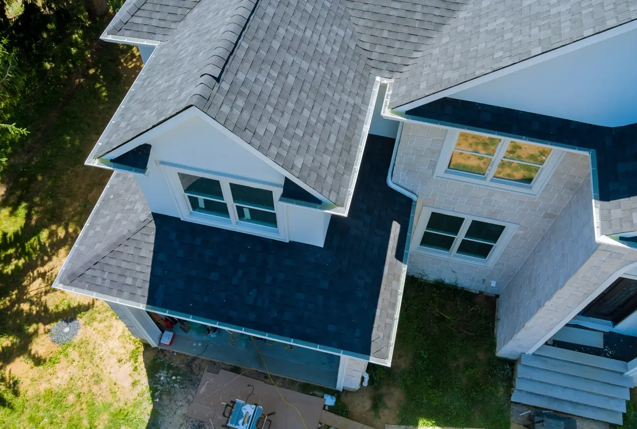 Aerial view of residential roof under construction with partially installed shingles