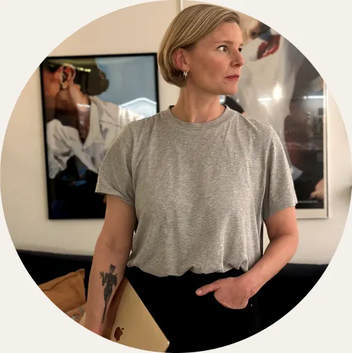 Bild på Sara, grundare av Sarai som står med en laptop i ena handen. 