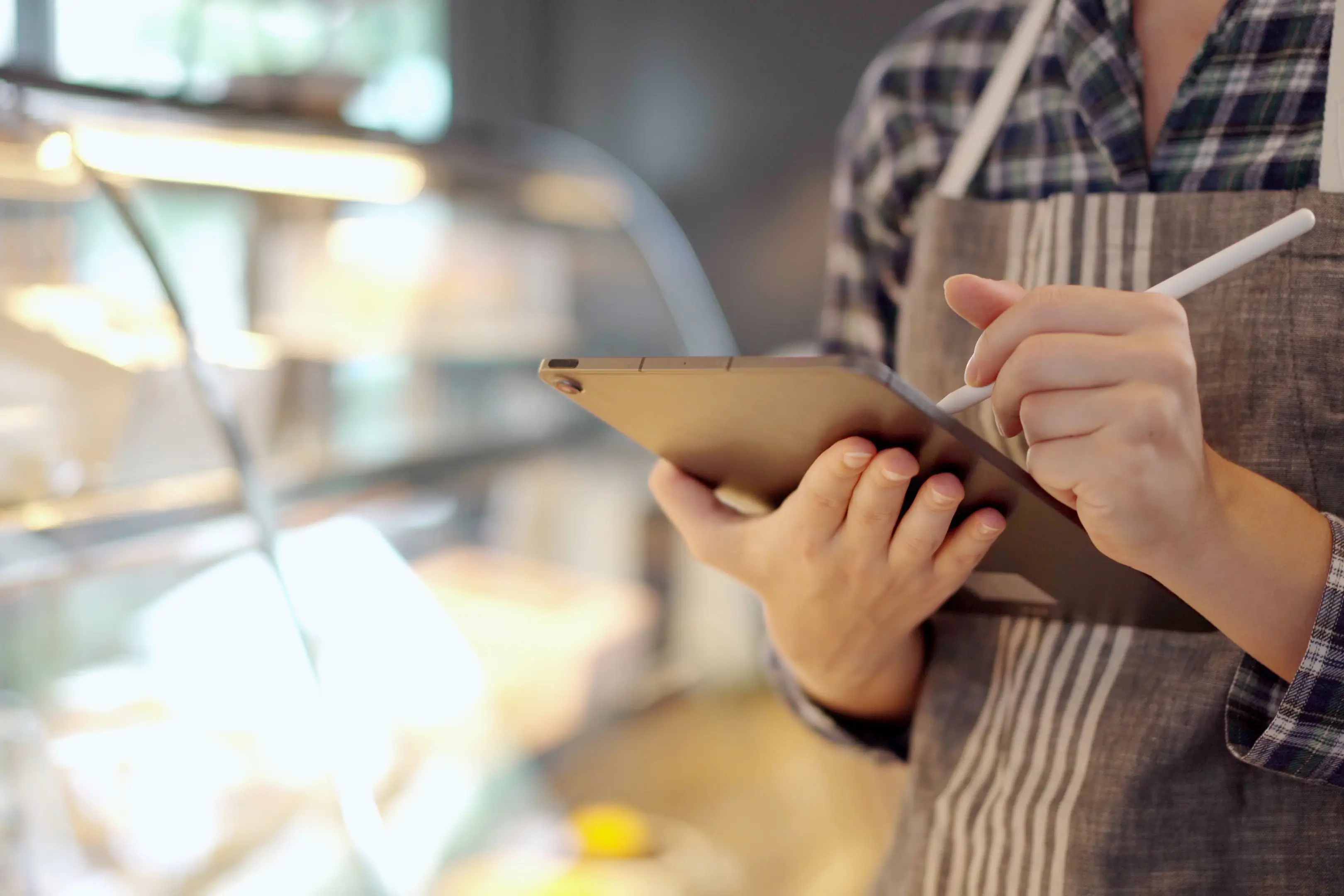 Boulanger utilisant une tablette pour suivre ses prix et analyser ses factures en boulangerie-pâtisserie