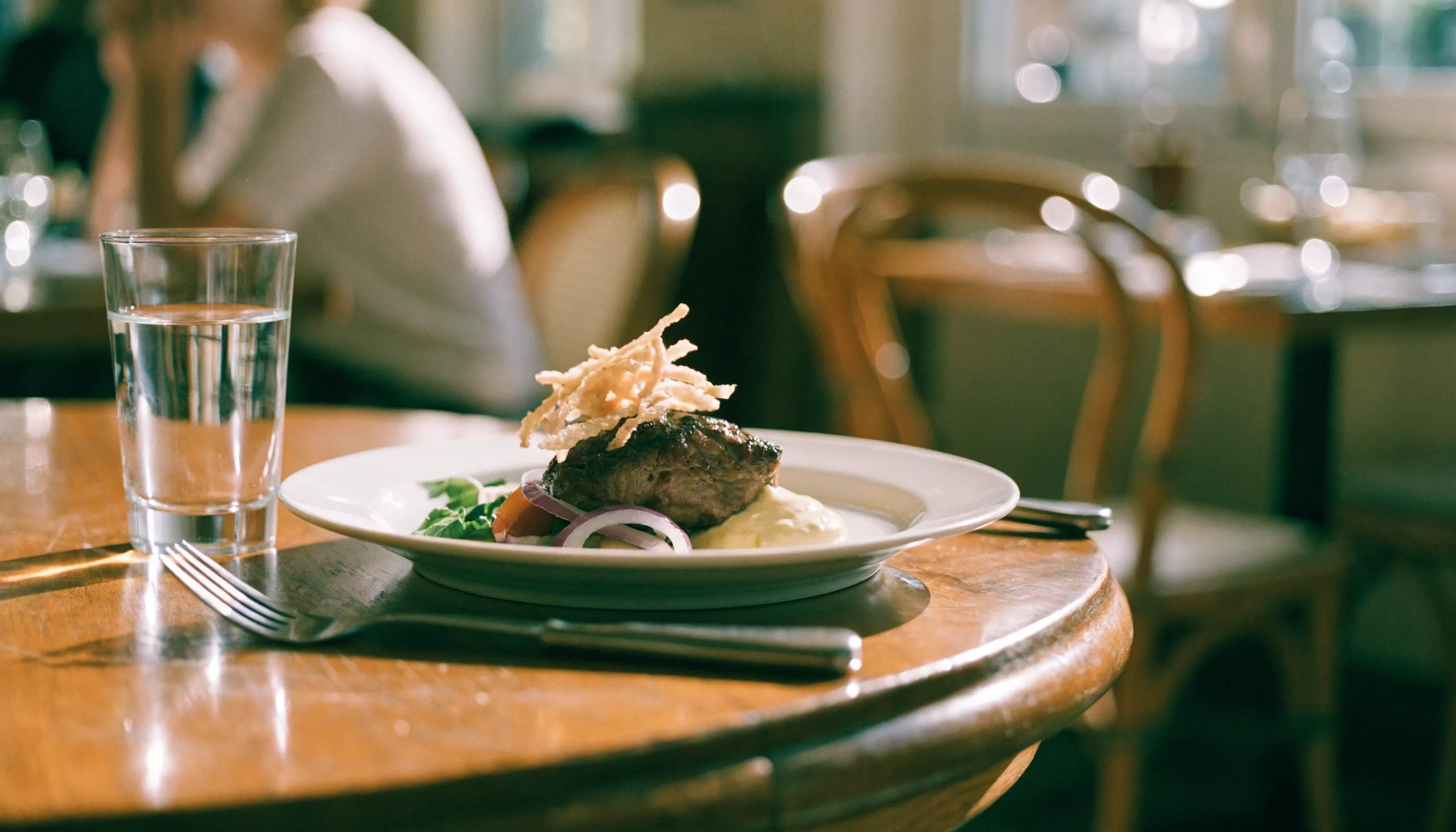 Plat dressé servi sur une table en bois dans la salle d'un restaurant, illustrant la marge réalisée sur chaque assiette