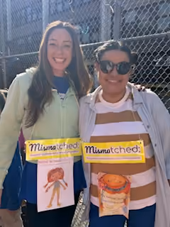 Two students holding copies of the book Mismatched