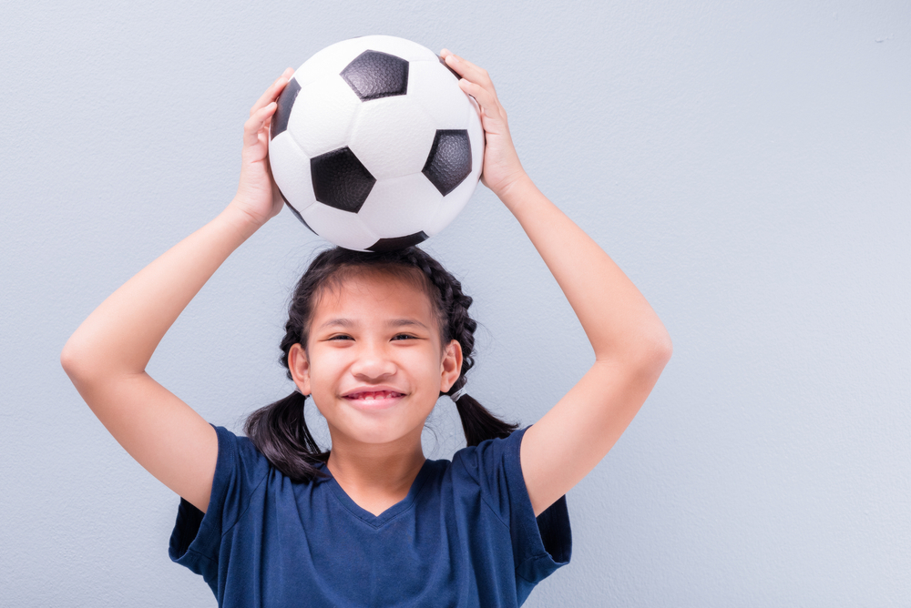 A girl holding a sports ball
