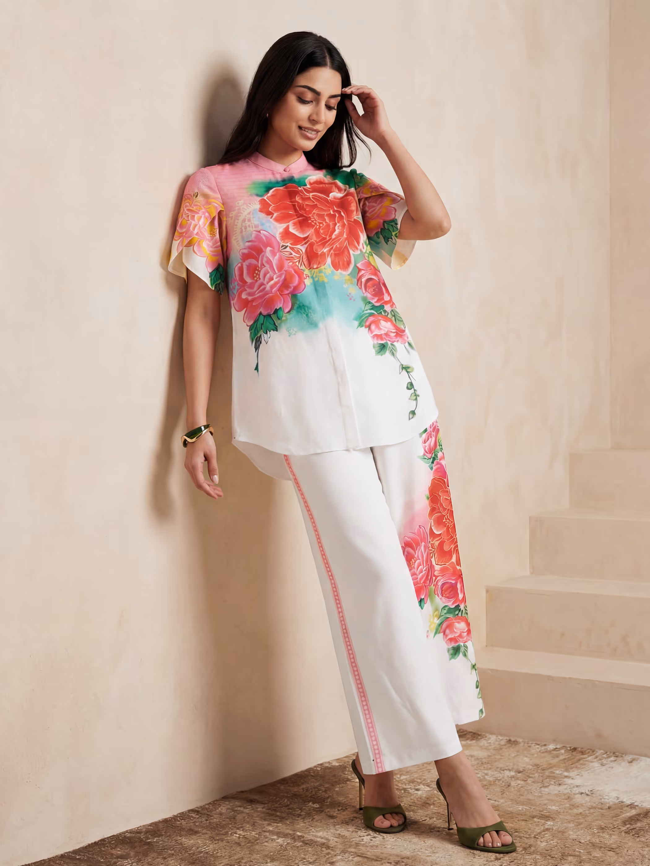 Model wearing a white two-piece satin co-ord set featuring a vibrant red and pink floral design.