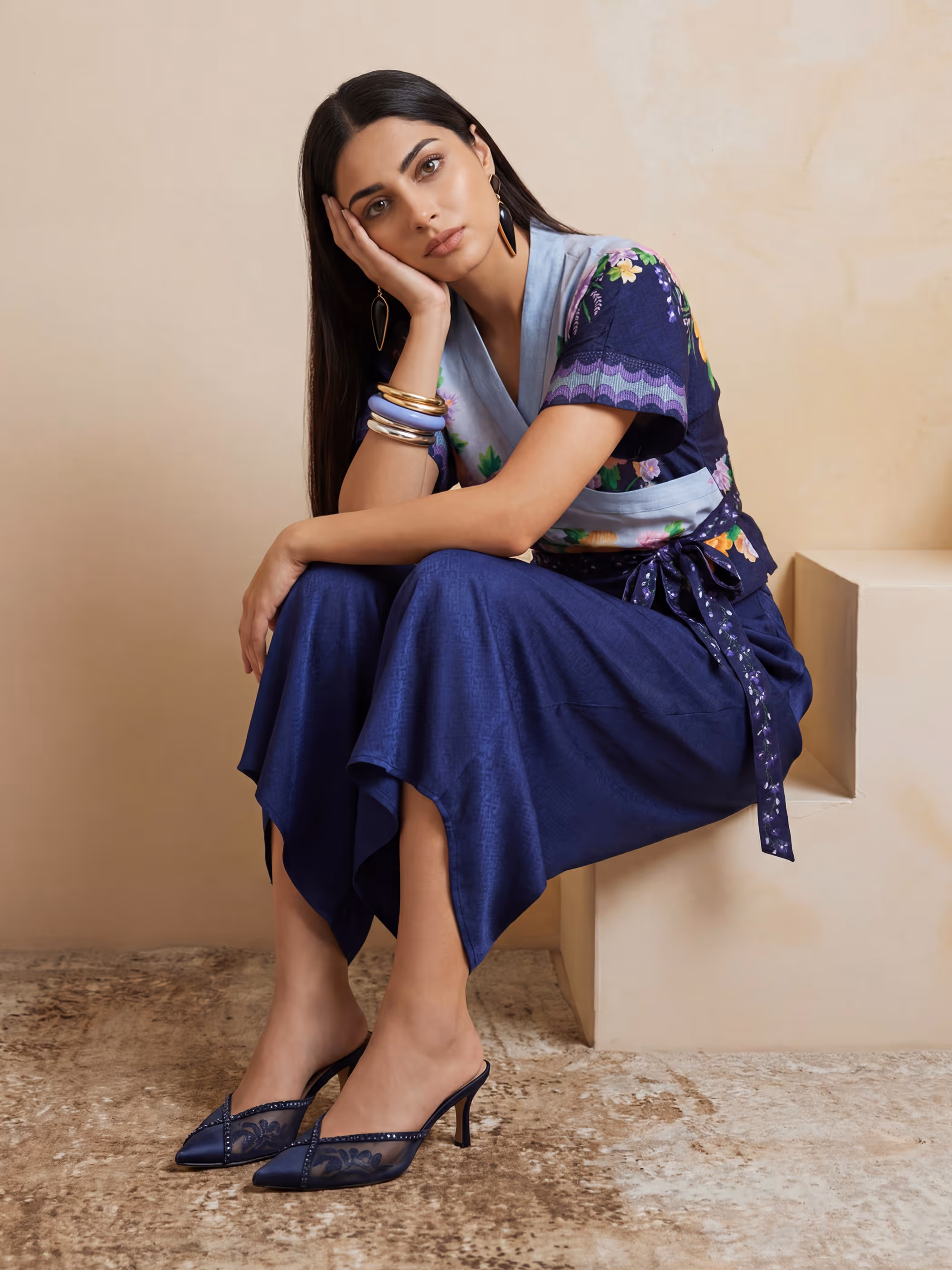 Model in a deep blue wrap tunic with a floral v-neck bodice and matching wide-leg trousers.