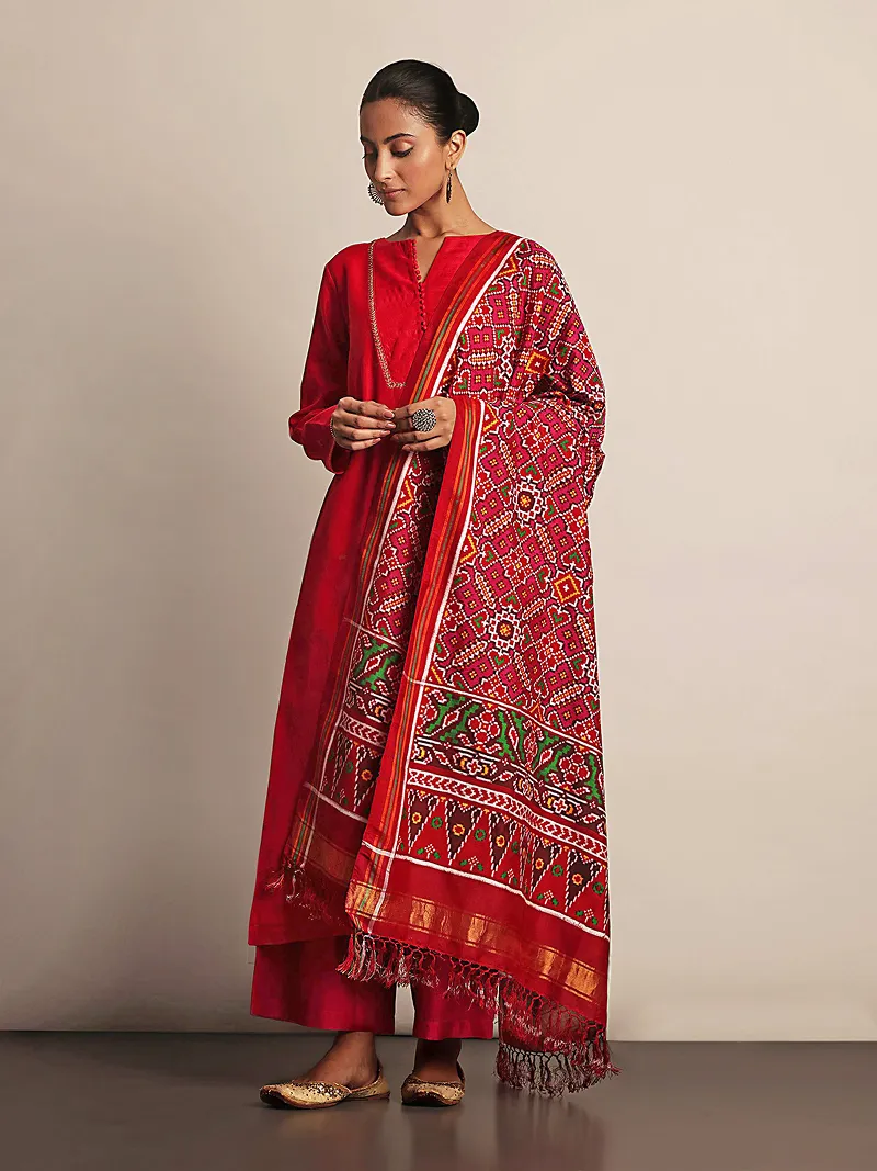 Model in a red traditional Indian suit with a patterned red dupatta.