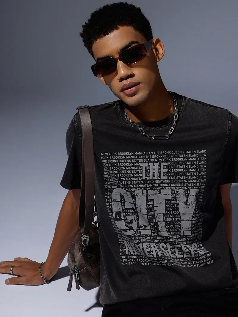 Male model in a dark grey graphic t-shirt.