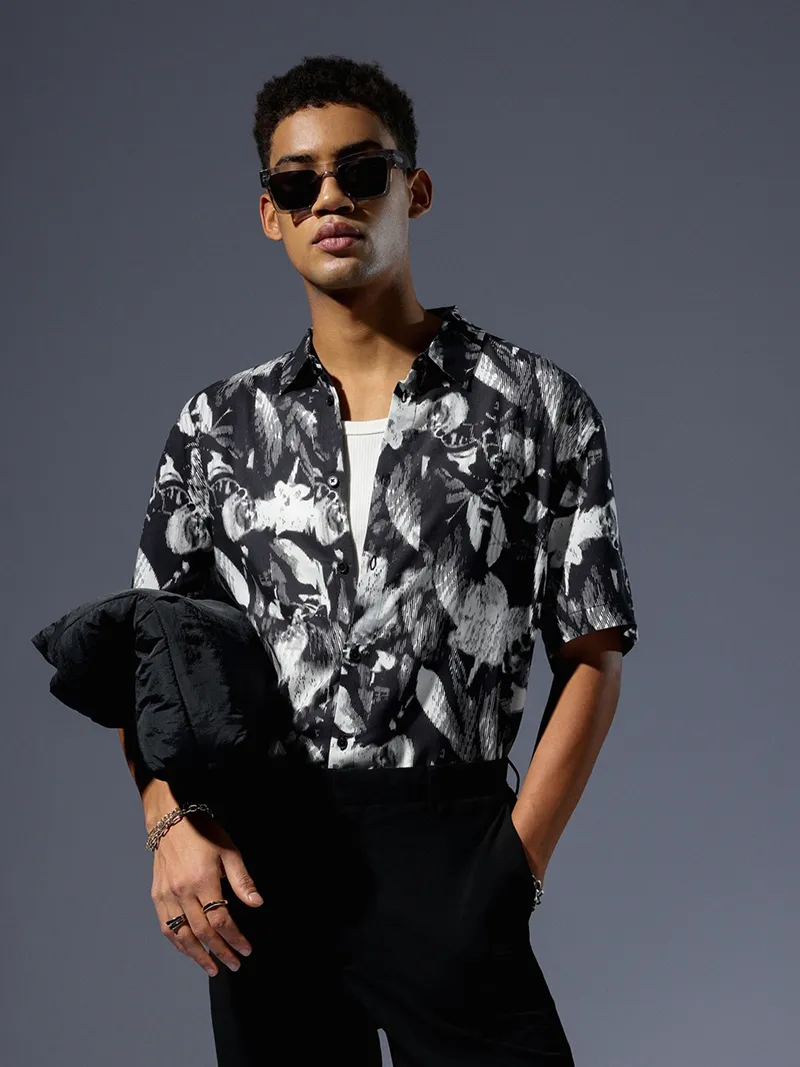Male model in a black and white patterned short-sleeve shirt.