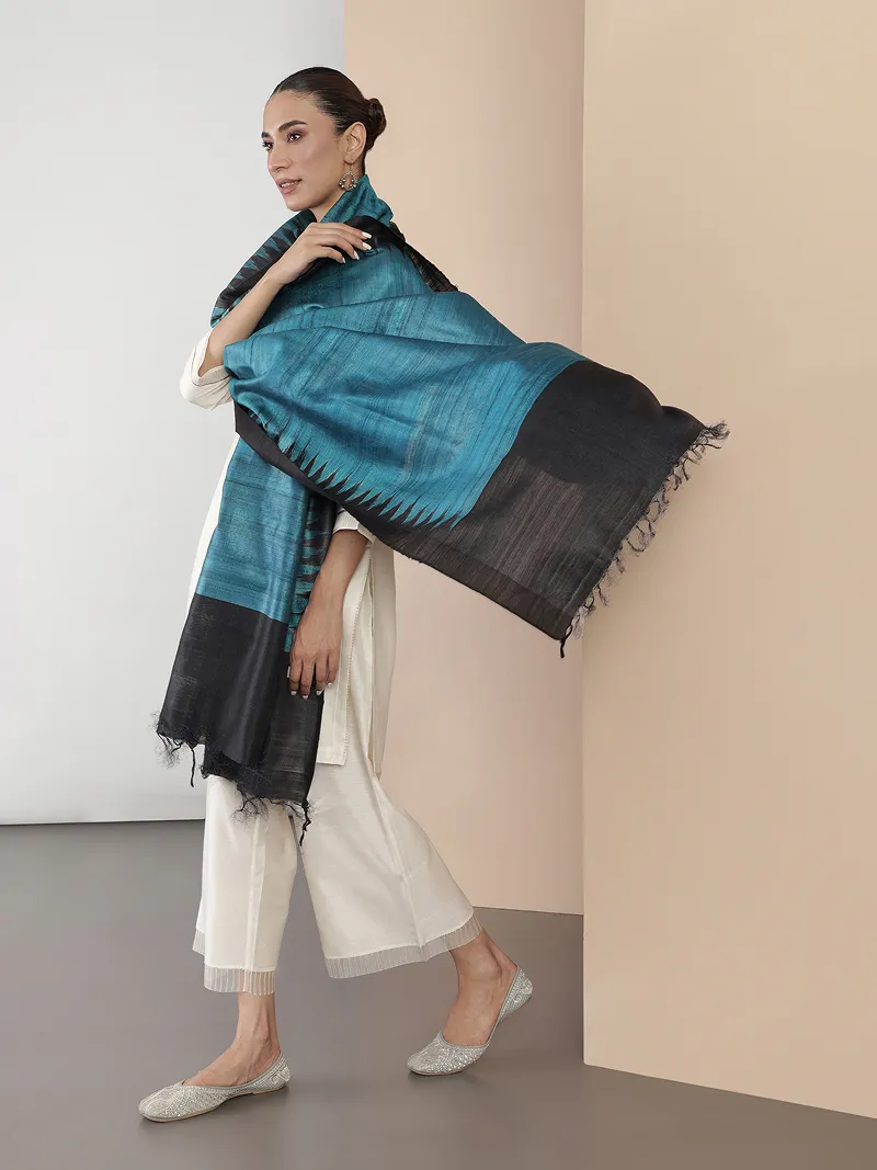 Model in a cream outfit with a teal and black silk dupatta.