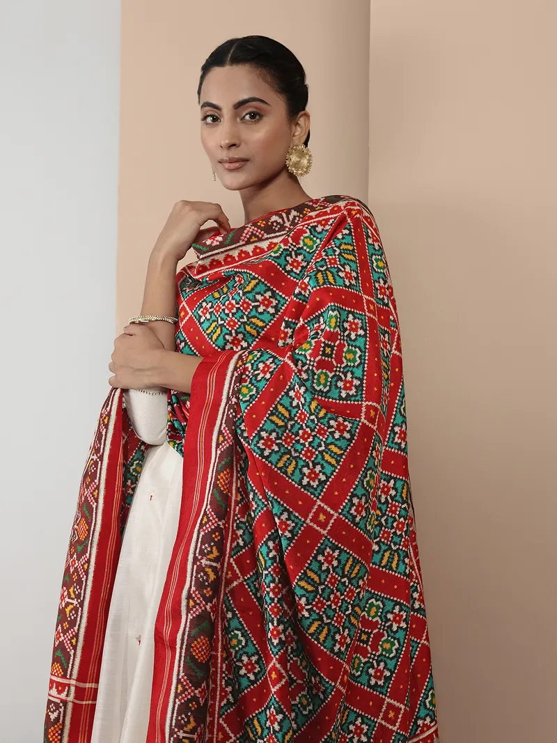 Model in a white outfit with a red geometric-patterned dupatta.