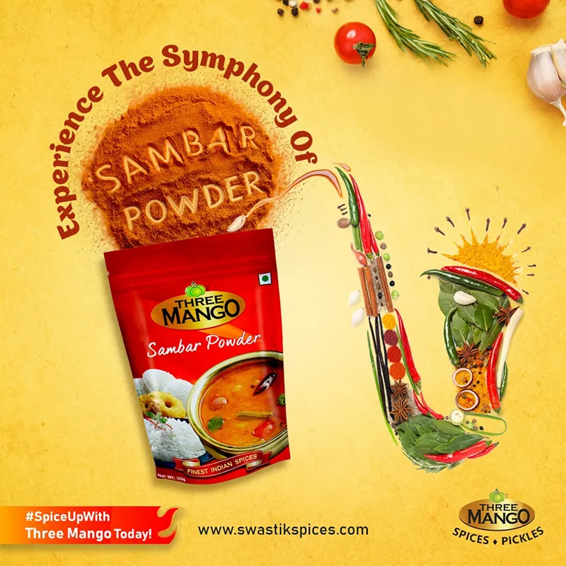Sambar powder pack surrounded by spice powder, curry leaves, chillies, garlic, and whole spices