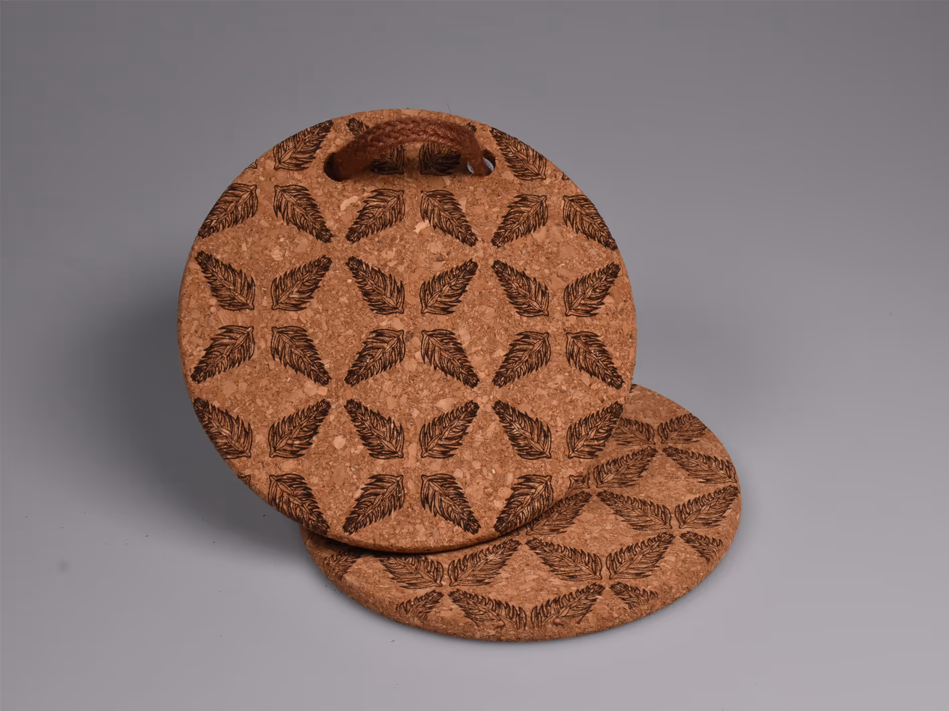 A laser-engraved Araucaria tree node pattern on a cork coaster, forming a symmetrical snowflake.