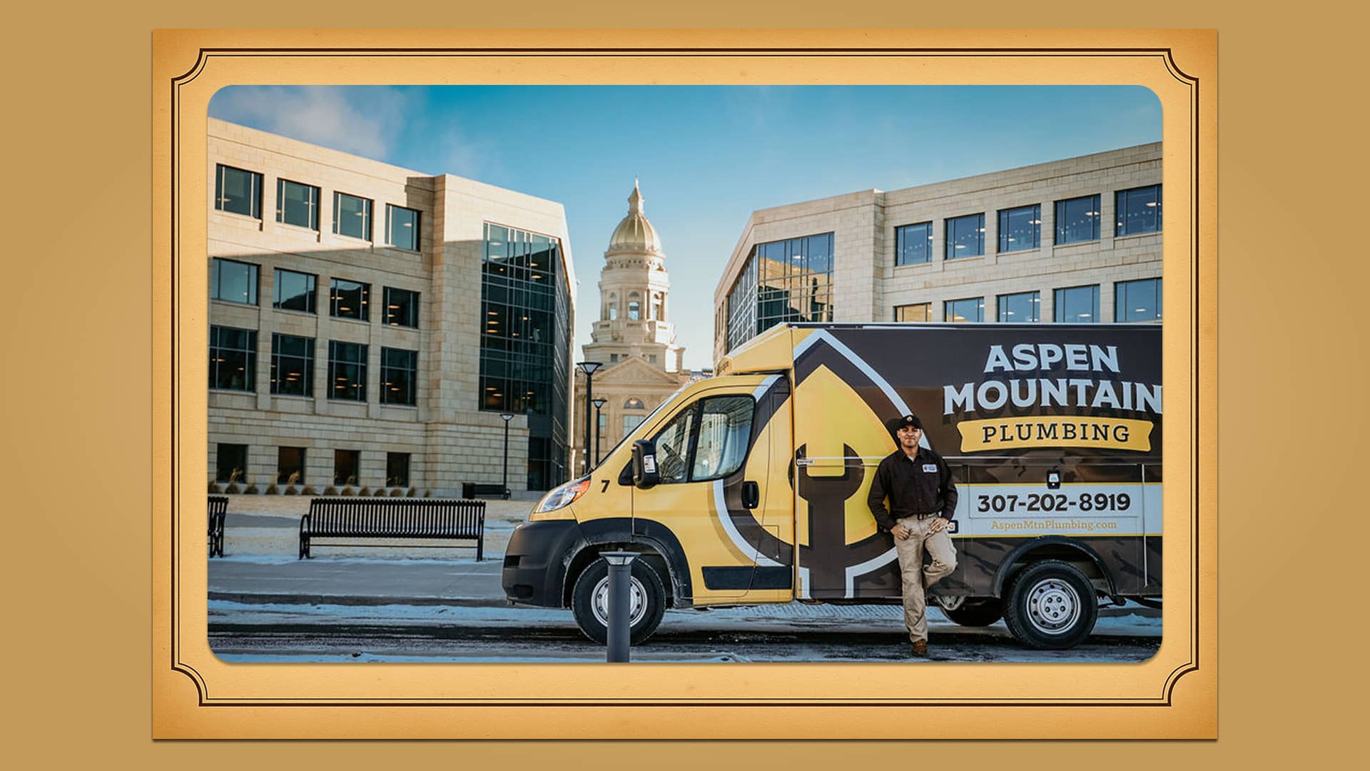 Travis James of Aspen Mountain Plumbing standing next to the company van in front of the Wyoming State Capitol in Cheyenne.