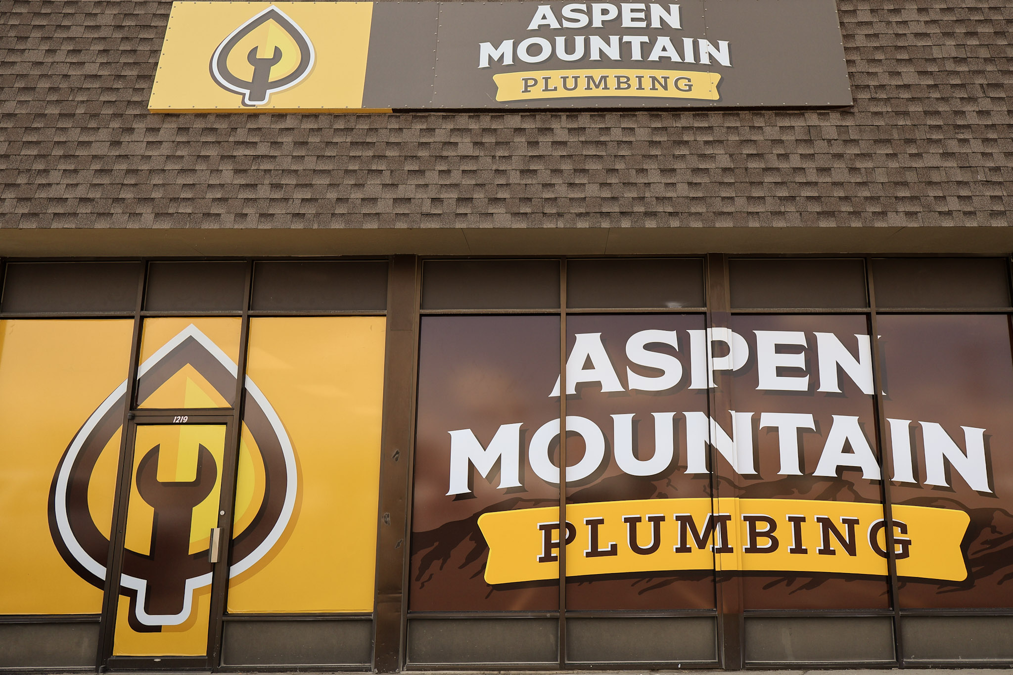 Brown and gold Aspen Mountain Plumbing signage featuring the Gold Leaf logo in Rock Springs, Wyoming.