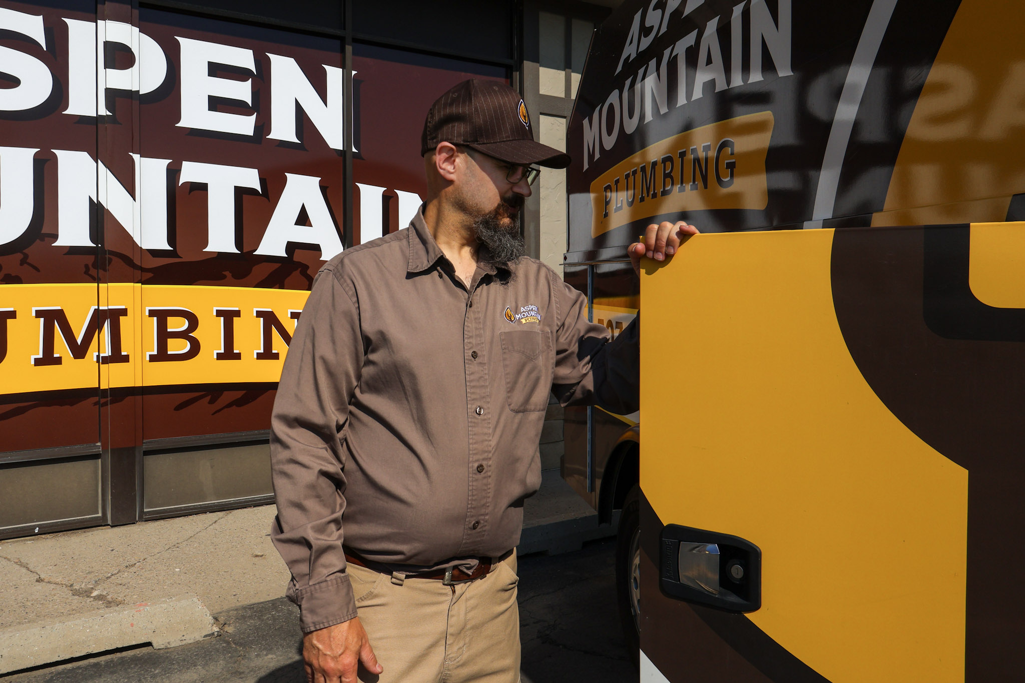 Owner Lance Ball at the door of an Aspen Mountain Plumbing service van. 