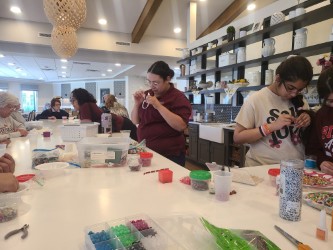 Seniors creating bracelets during craft time