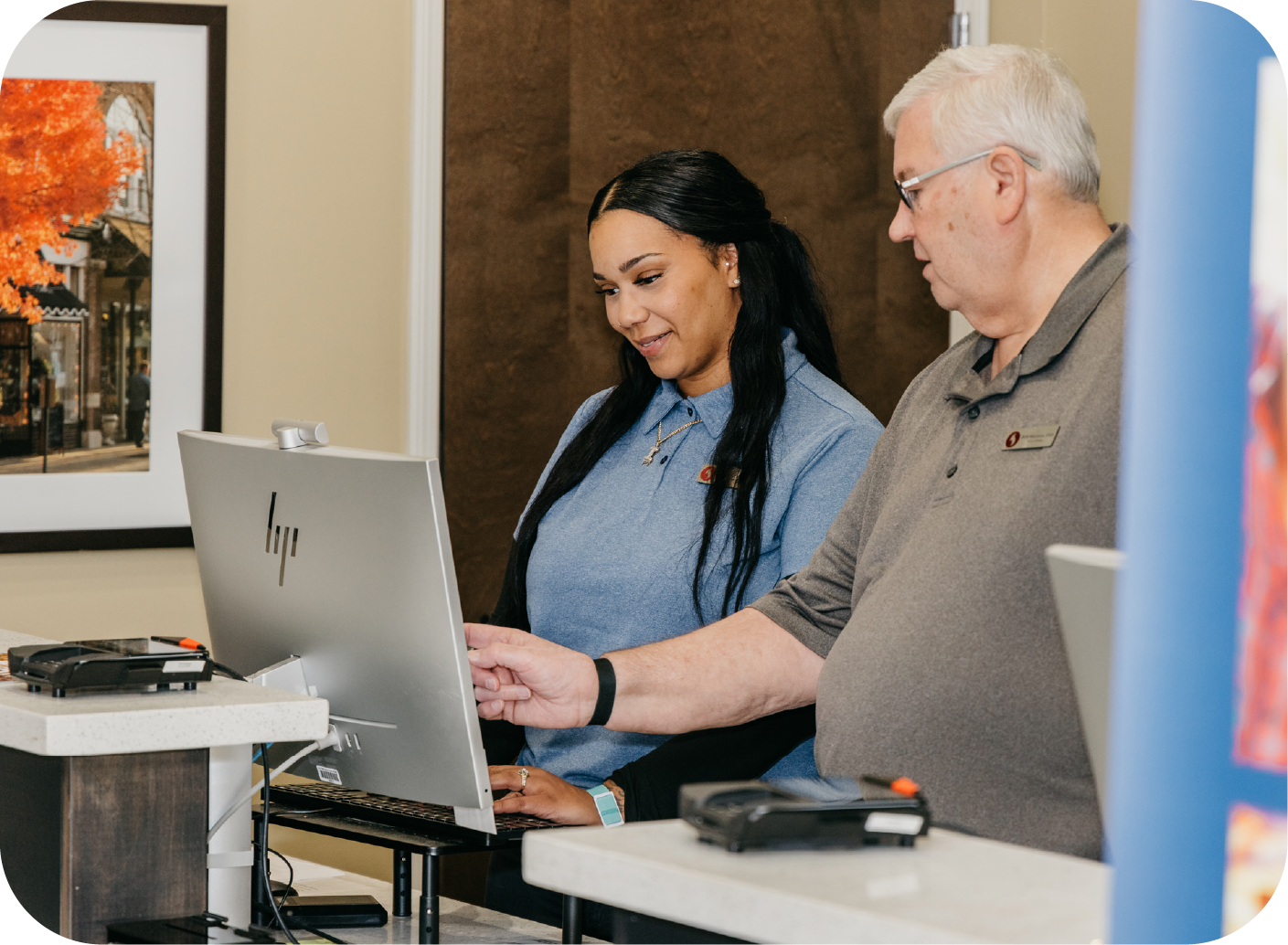 Two hotel employees reviewing hotel operations software together during a technology training session.