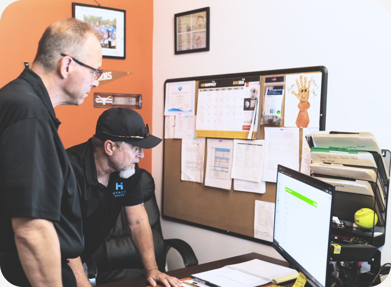 Two hotel employees reviewing operational information together on a computer to support property management and day-to-day decision-making.