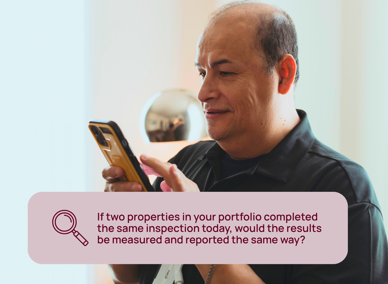 Hotel leader reviewing inspection information on a mobile device while evaluating whether inspection results are measured and reported consistently across properties.
