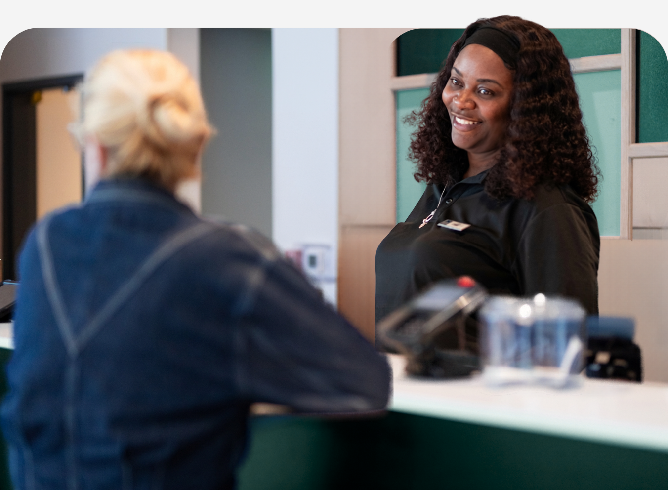 Hotel employee assisting a guest at the front desk during check-in or while addressing a service request.