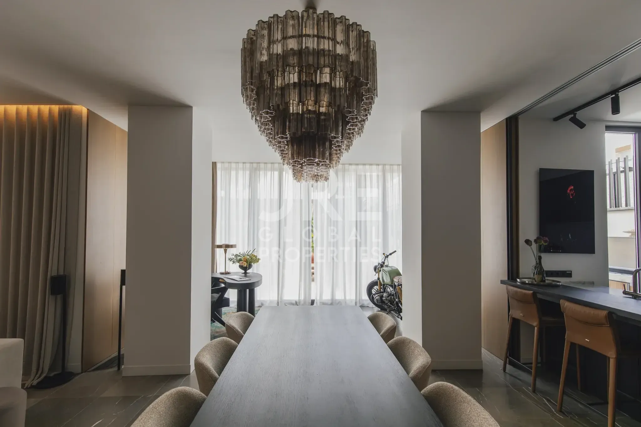Dining table seating ten under a tiered chandelier.