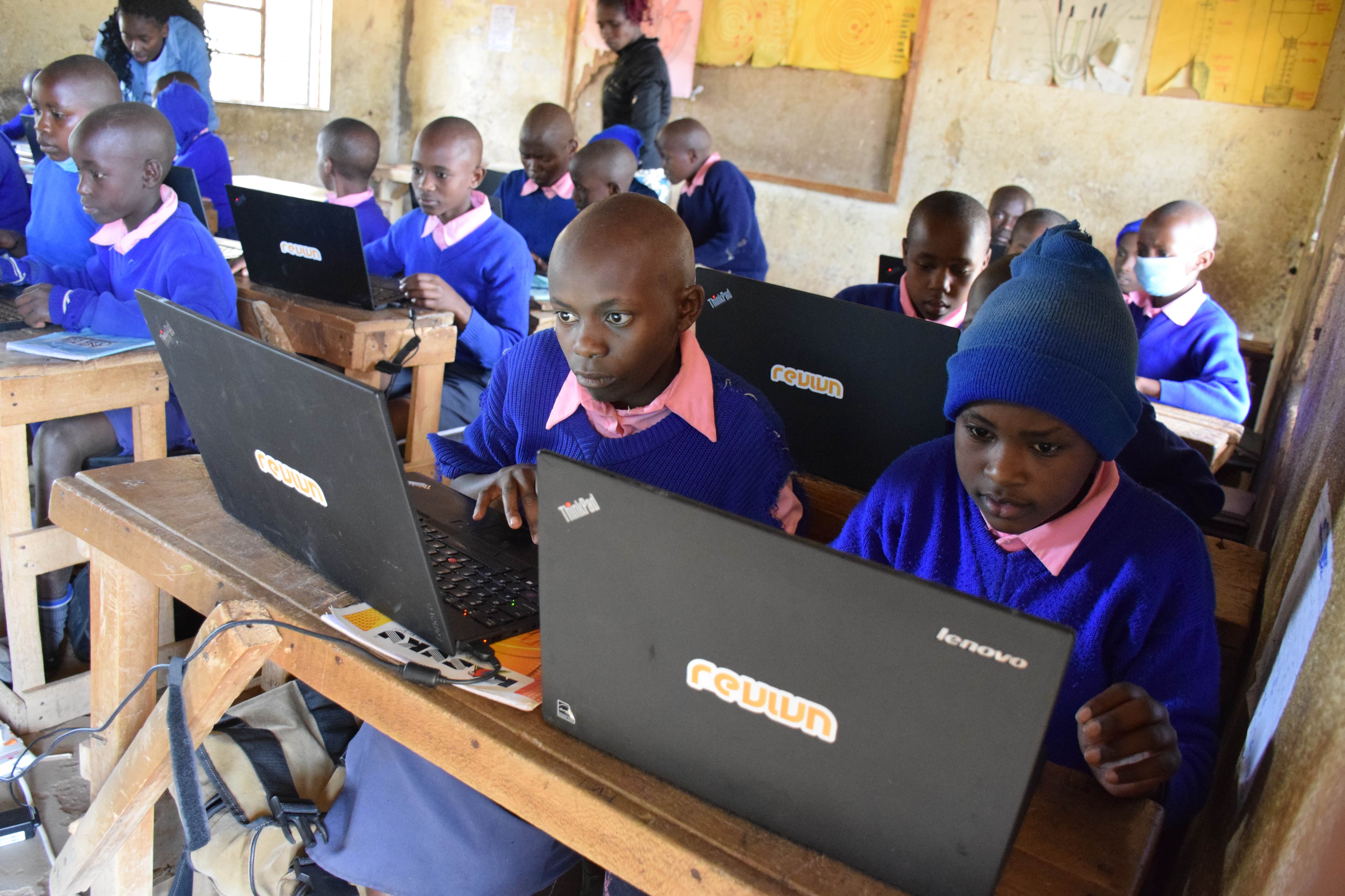 Kids in Kenya using donated Revivn laptops in a classroom