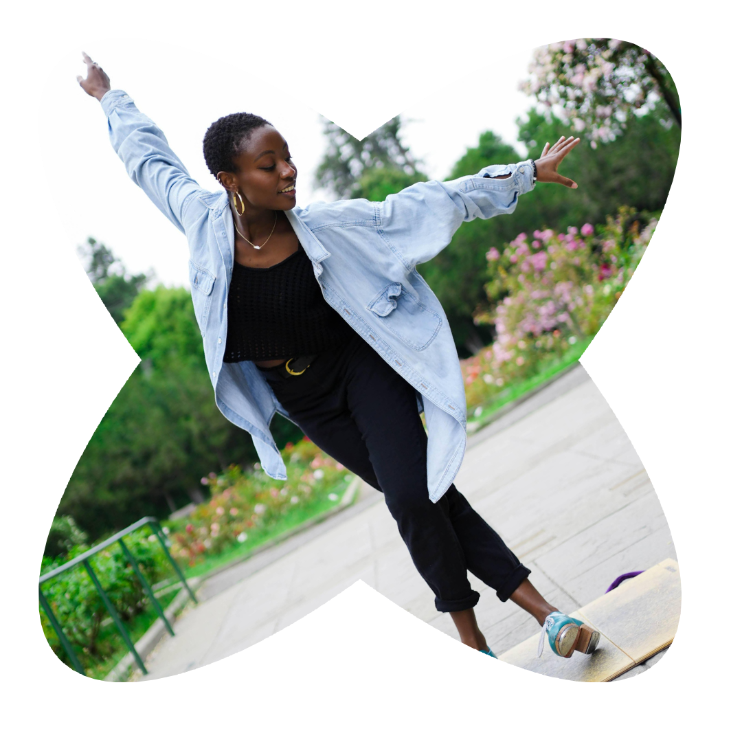 Photo: Micah St. Clair Sallid by Andrio Jordan Fong Image Description: Dancer in Blue Shirt and turquoise tap shoes jumps into the air off of a board in a rose garden.