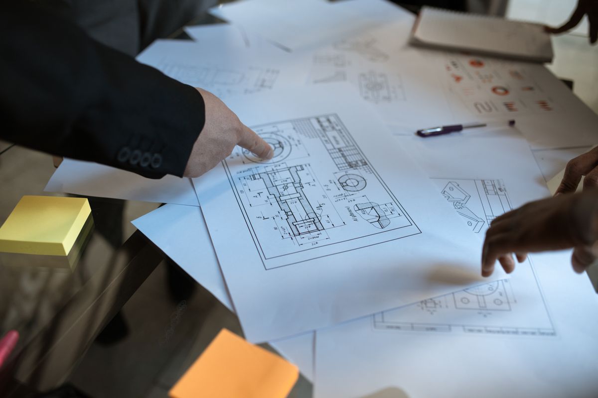 Project team reviewing technical drawings and delivery plans.