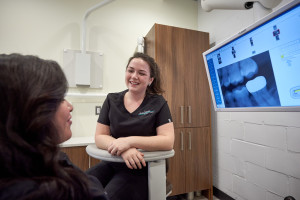 A dentist shows a dental patient their oral scans at a Dental Image Therapy Centre location.