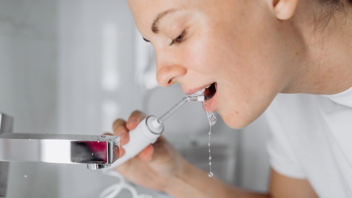 A woman using a water flosser