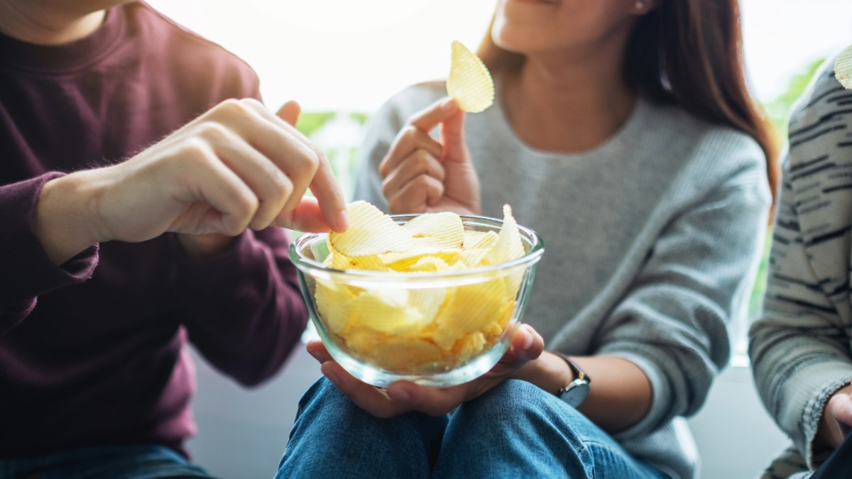 People snacking on potato chips