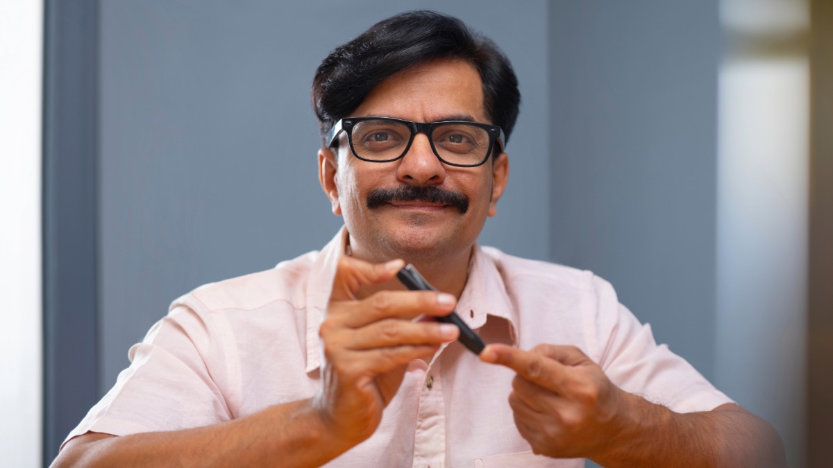 A smiling man using a blood sugar tester