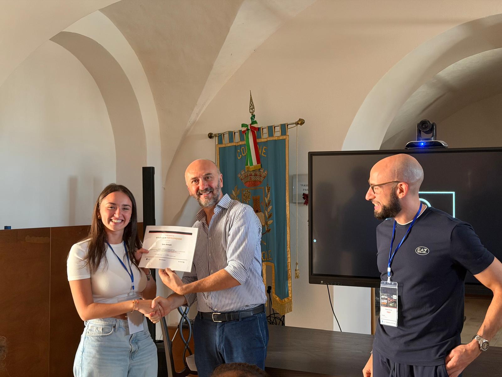 Consegna di un attestato durante la chiusura dell’Academy