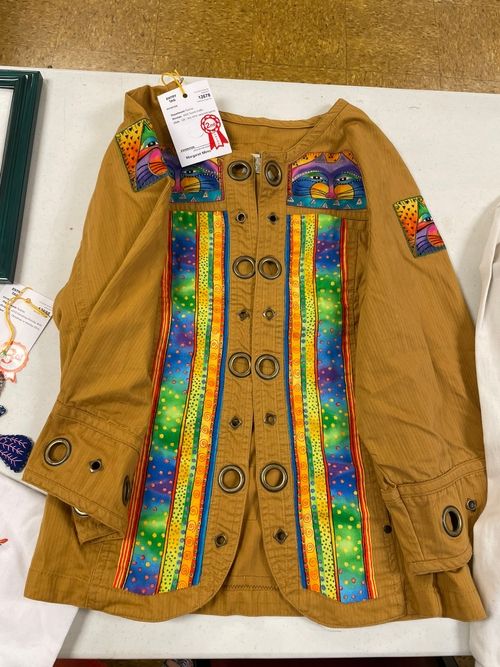 Tan jacket embellished with rainbow fabric panels and cat appliques