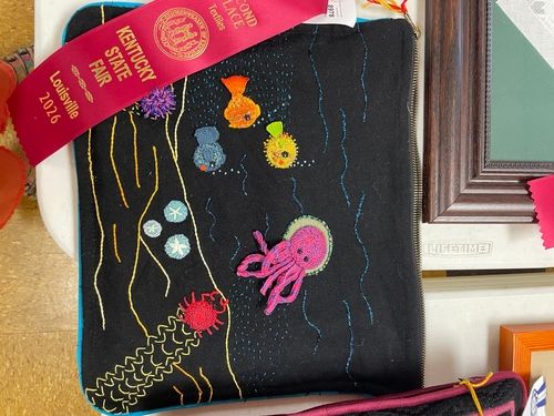Black embroidered panel with jellyfish and sea creatures, second place ribbon