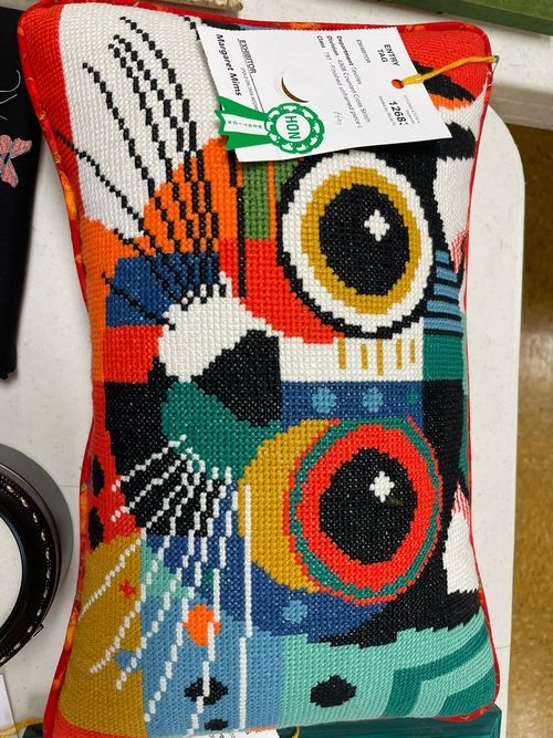 Needlepoint pillow with a bold abstract design in bright colors