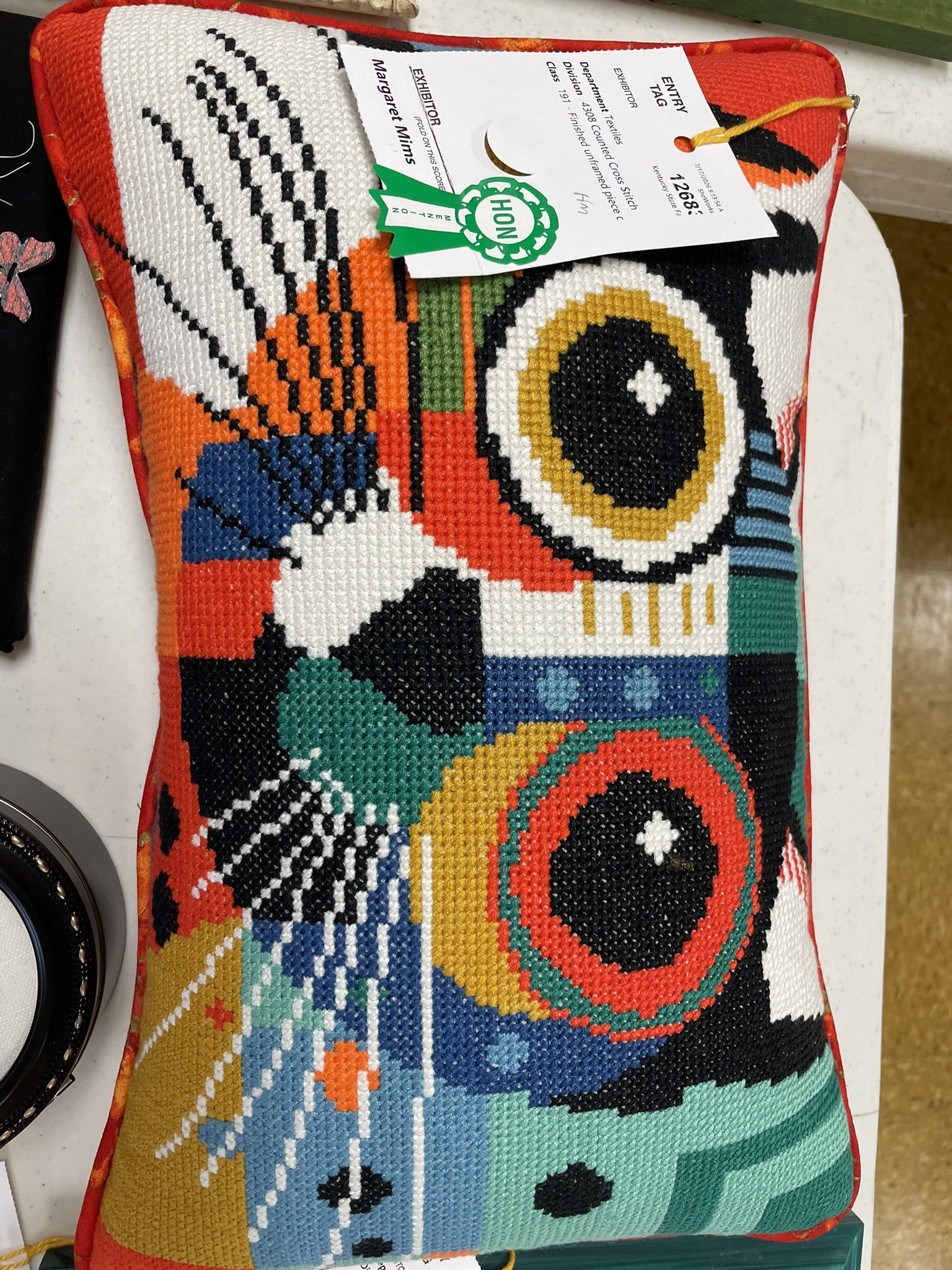 Needlepoint pillow with a bold abstract design in bright colors