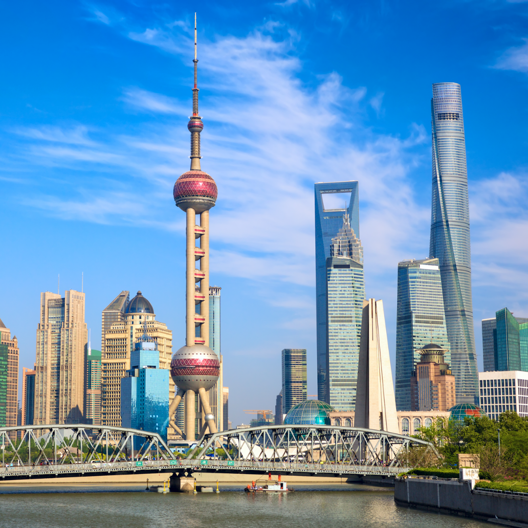 Cityscape photo of Shanghai China, with towering skyscrapers and a bridge over water