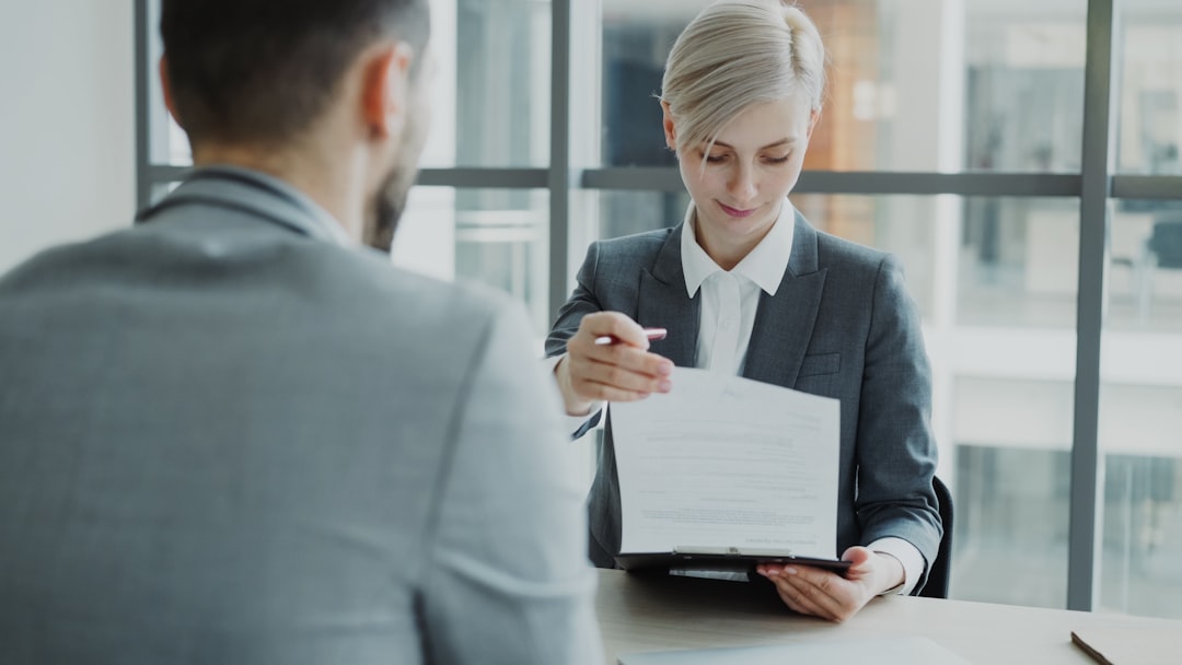 Woman in suit presenting legal document to man, illustrating counsel reviewing opposing submissions with AI legal research support