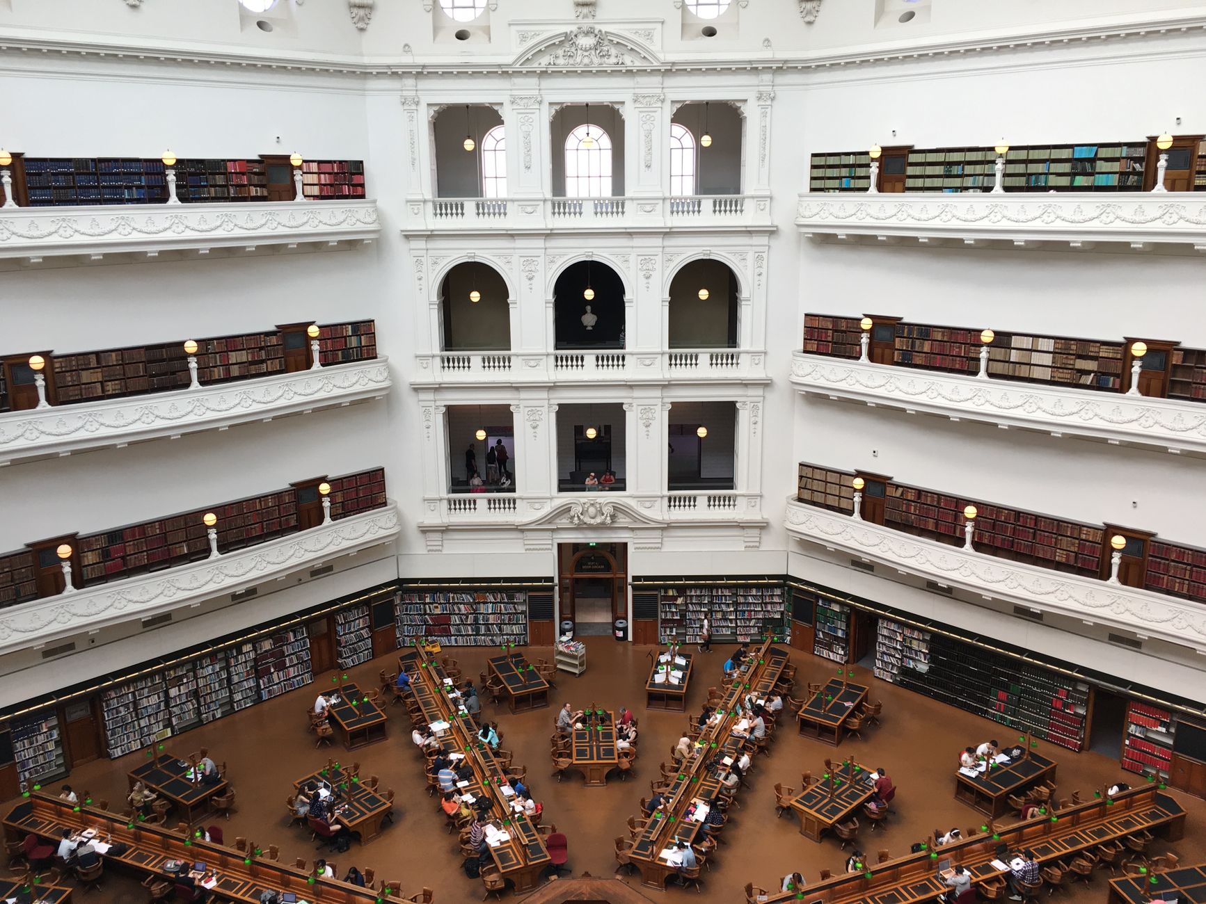 Multi-level library interior with study desks and bookshelves, illustrating why a PMS alone is not enough for Australian legal AI research.
