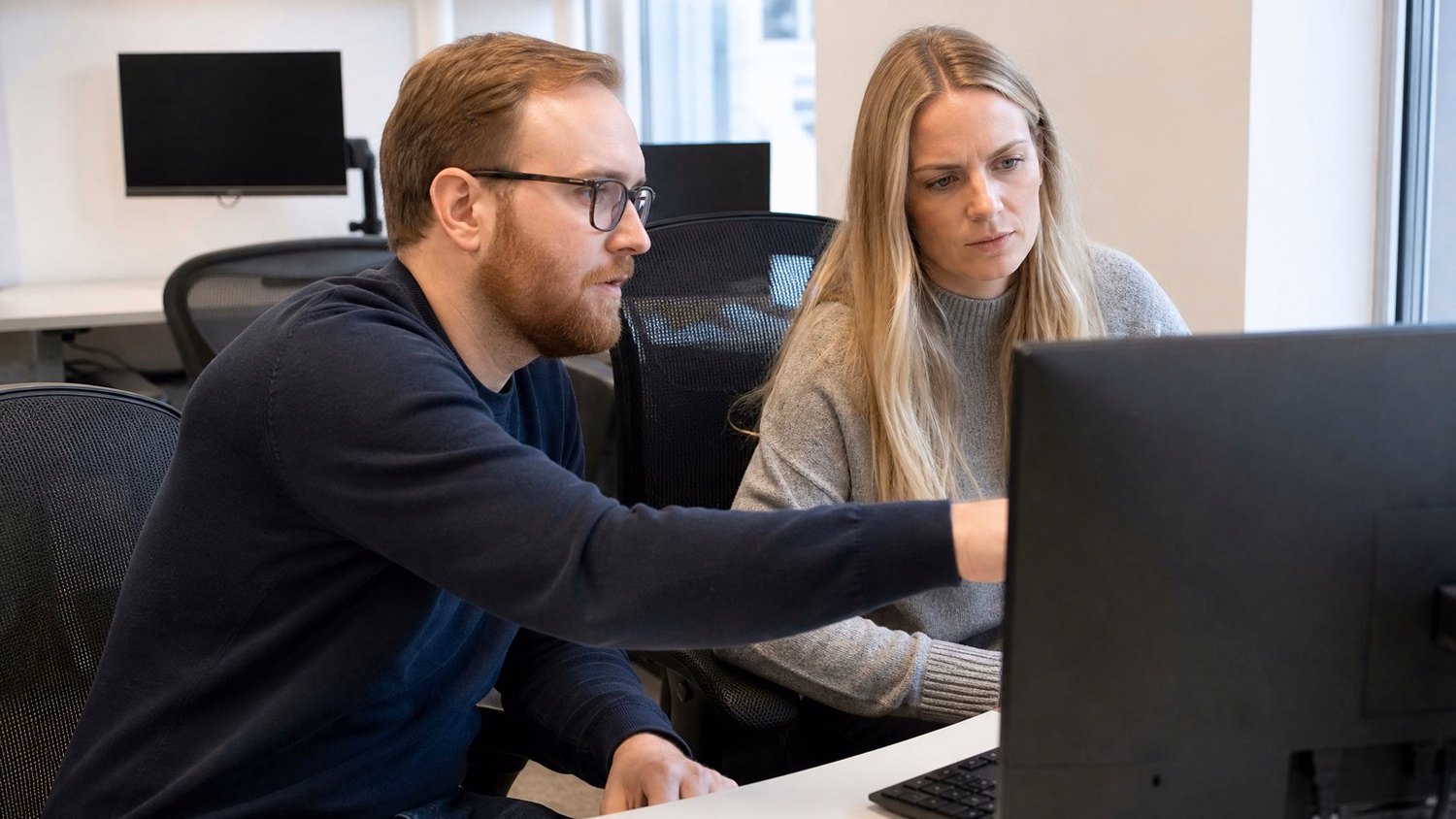 SIDE-BY-SIDE PAIR An IT professional  two people seated side by side reviewin